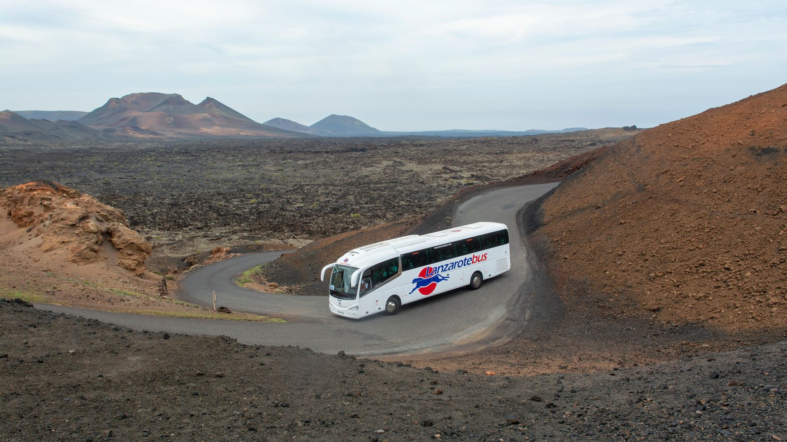 Motorcoach parked outside a hotel with passengers boarding