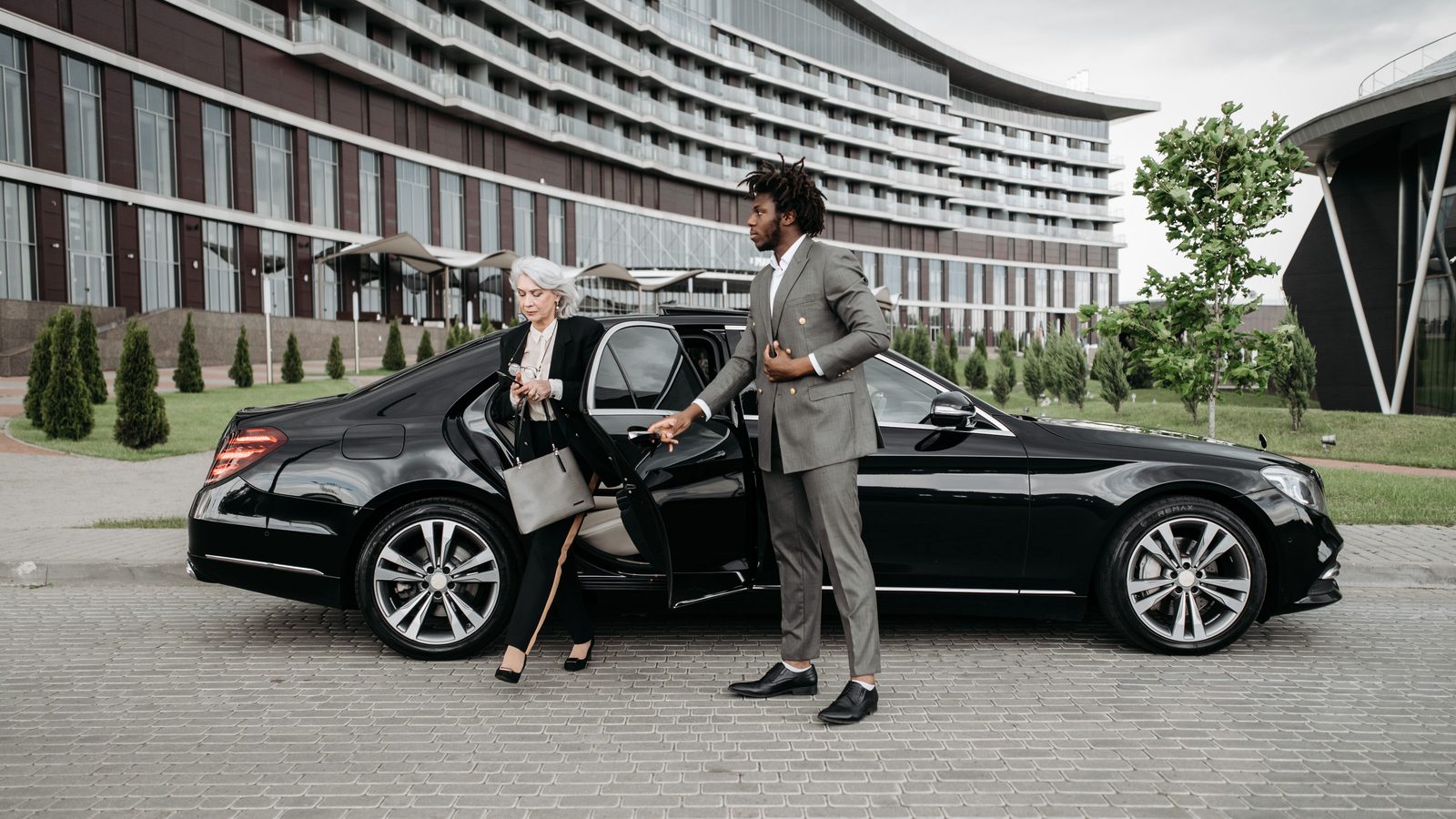 Black executive sedan waiting at a hotel entrance